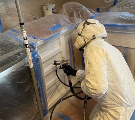 a painter working on kitchen cabinets
