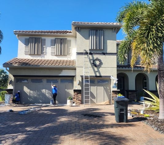 PAINT CORPS&reg; crew painting exterior of house