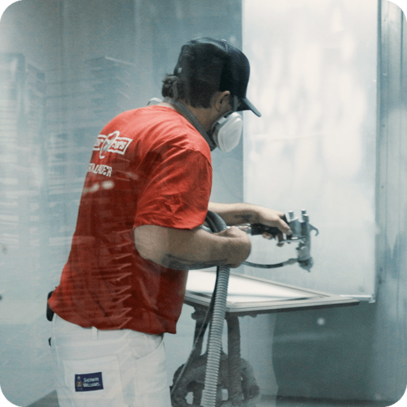 gentleman spraying cabinets with paint gun